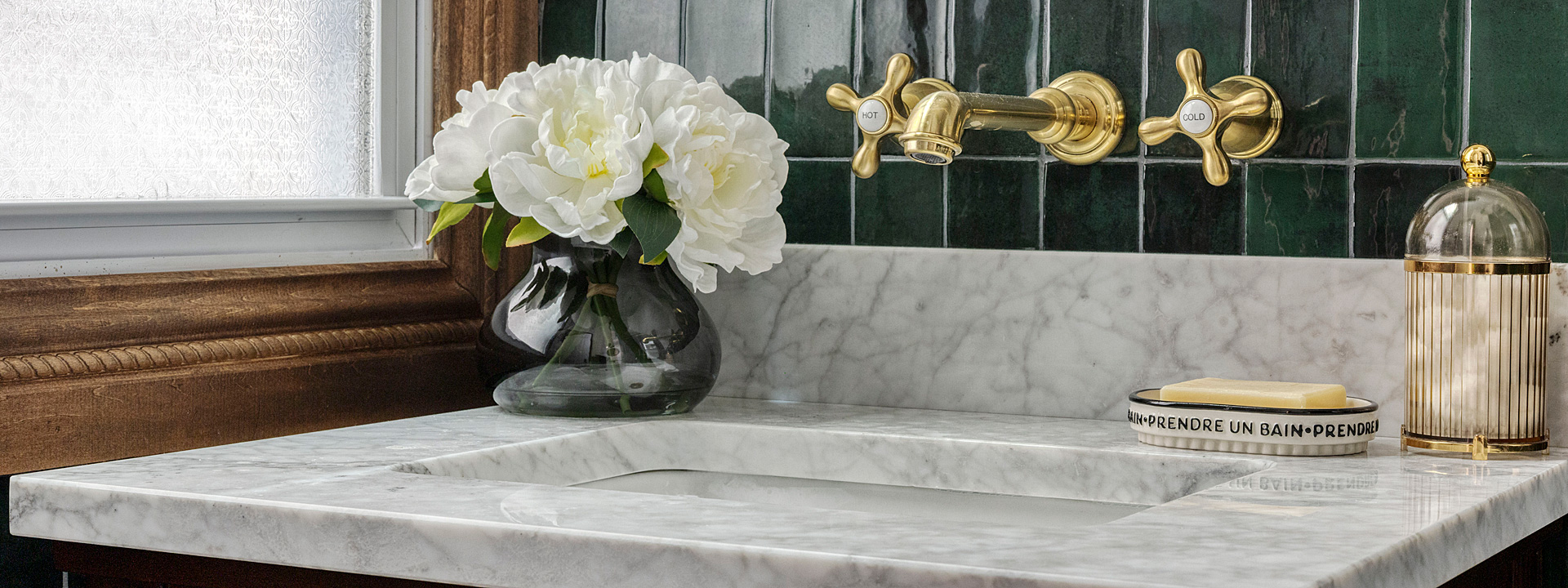 Brooklyn Brownstone Bath: glossy emerald tile, a brass-framed mirror and a marble-topped vanity