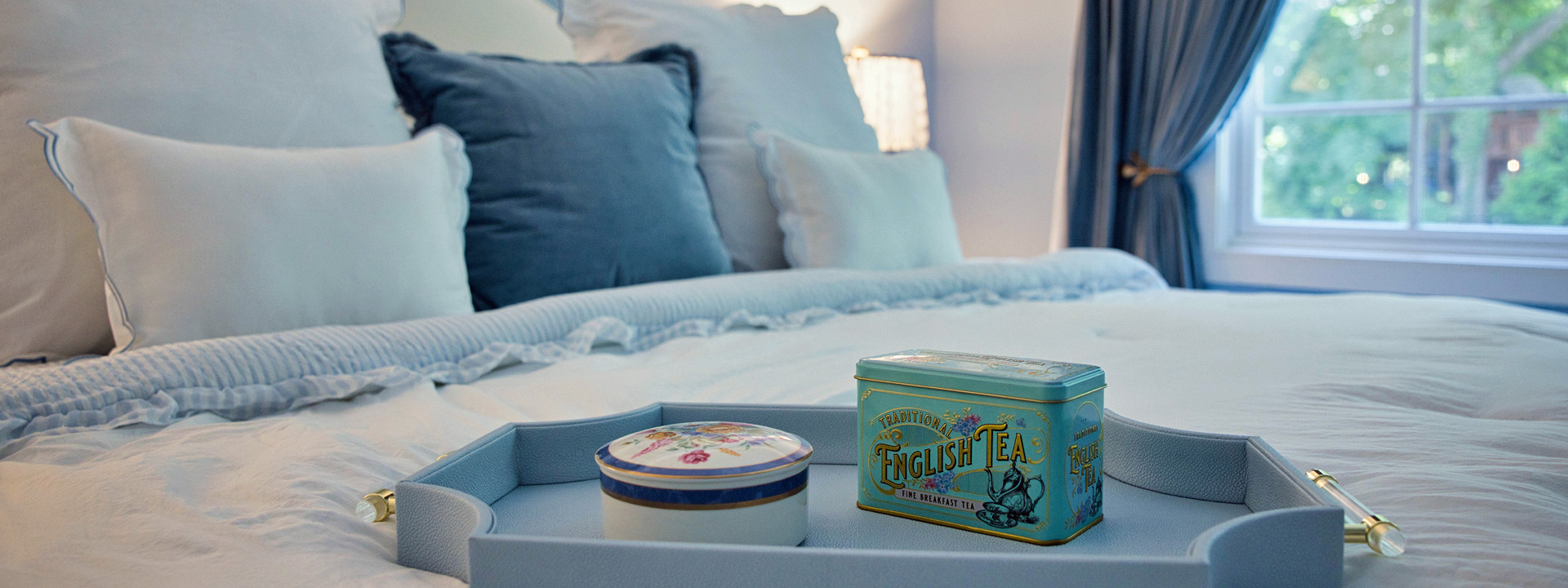 The Treasured Guest: a serene blue guest bedroom with plate wallpaper on the ceiling and heirloom artwork
